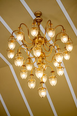 Orange light chandeliers installed on the ceiling of the hotel banquet hall.