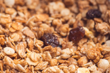 Useful and tasty muesli with nuts, rasins and flakes. Selective focus macro shot with very shallow depth of field. Healthy and vegetarian lifestyle