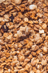 Useful and tasty muesli with nuts, rasins and flakes. Selective focus macro shot with very shallow depth of field. Healthy and vegetarian lifestyle