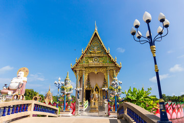 The Thai temple in Wat Plai Laem in Samui Island Thailand, in the middle of the water, contains giant statues and elephants.Pigeon flies through.