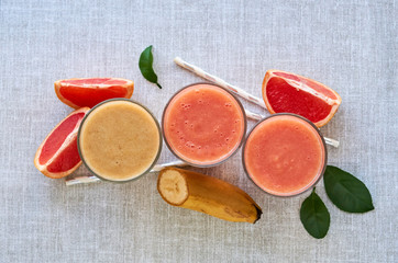 Grapefruit and banana smoothie on a gray background 