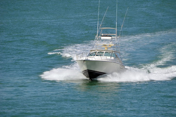 Fototapeta premium Speeding sport fishing boat leaving a wake trail on the florida intra-coastal waterway off Miami Beach.