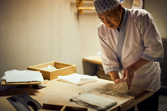 手打ち蕎麦の打ち粉を払う