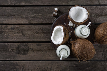 Fototapeta na wymiar Coconut milk in bottles on wooden table. Vegan non dairy healthy drink. Healthy eating concept