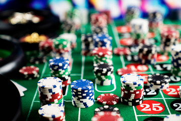 Casino felt green table with red and black numbers. Stack of poker chips.