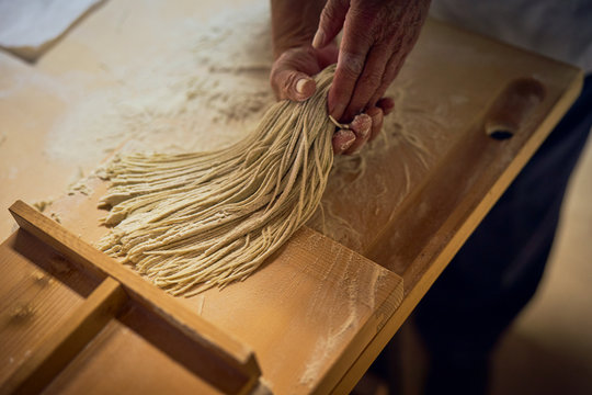 手打ち蕎麦の打ち粉を払う