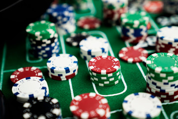 Casino felt green table with red and black numbers. Stack of poker chips.