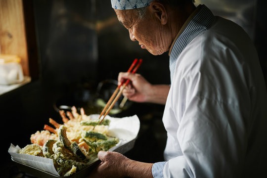 天ぷらを揚げる料理人