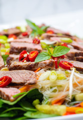 Thai beef style salad with noodles, chilli and basil. Selective focus, close up