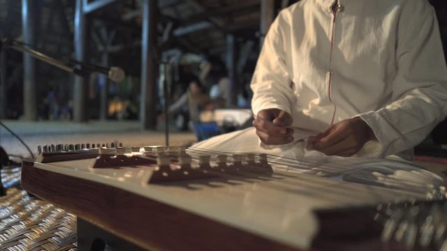 Man playing on on Chinese Hammered Dulcimer 
