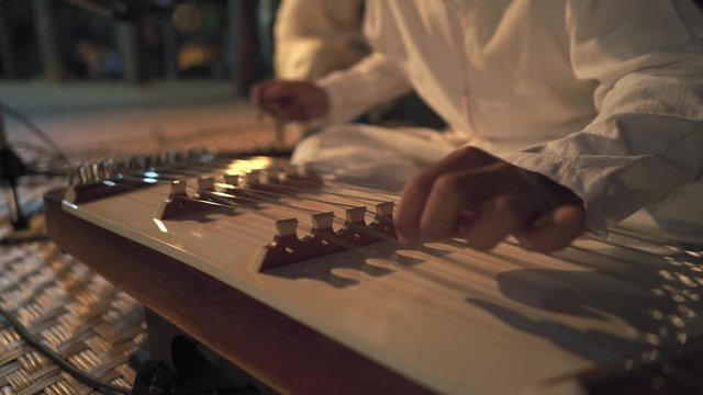 Man playing on on Chinese Hammered Dulcimer 
