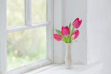 tulips in vase on white windowsill