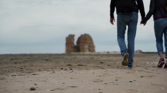 Lovers couple walking near ruins of Torre Flavia in Ladispoli, Italy