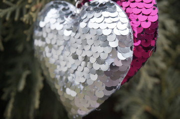 Silver heart on a green blurred ceramic tile background