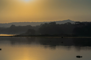 Fototapeta na wymiar Sunrising over the lake with reflection mist on the water, Landscape sunrise concept