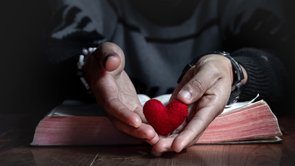 Red heart in hands of man, Close up, love of christian concept.