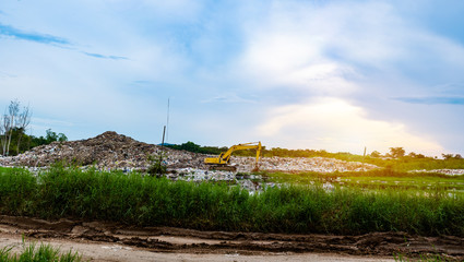 Backhoe is lifting refuse at waste separation plant, Mountain large garbage pile and pollution