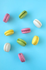 Top view of colorful macarons on blue background