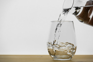 Motion blur of pouring pure drinking water flow into the glass making splash of clearly bubble