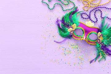 Holidays image of mardi gras masquarade venetian mask over purple background. view from above © tomertu