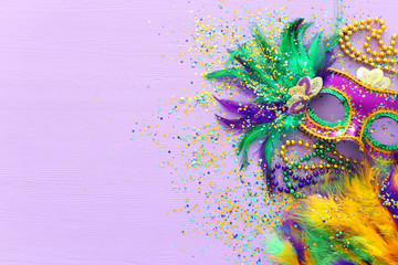 Holidays image of mardi gras masquarade, venetian mask and fan over purple background. view from above - obrazy, fototapety, plakaty