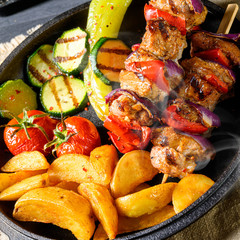 Shish kebab with various vegetables and spice country potatoes