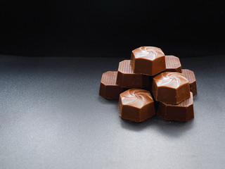 Close up photo of piled up milk chocolates from above view. Copy space