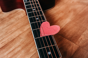 6 metal strings on a guitar and an eco-friendly paper heart on it, a picture for a loved one on a holiday or about a love of music