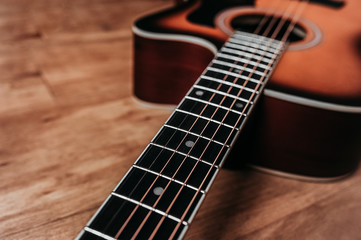 Fototapeta na wymiar element of a beautiful new clean guitar, six-stringed musical instrument mahogany guitar, metal strings close-up