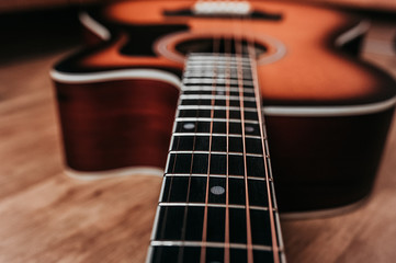 element of a beautiful new clean guitar, six-stringed musical instrument mahogany guitar, metal strings close-up