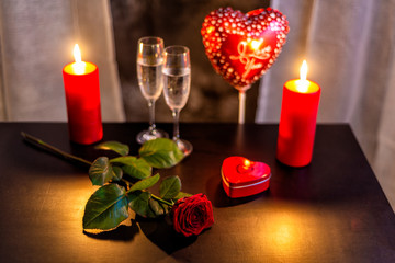 rote Rose, Sektgläser und Kerzen am Valentinestag