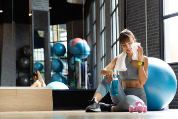 Young Asian Woman wiping sweat with towel in gym. Fitness and healthy lifestyle, Starting to exercise concept