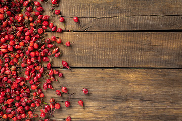 Wild rose on a wooden background in a rustic style, top view.