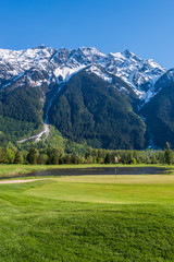 Golf course with gorgeous green and fantastic snow mountain view.