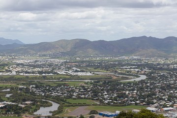 City seen from the top of the lookout with a crystal clear sea and the city in a perfect square with lots of vegetation and mountains. Townsview