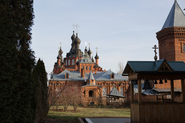 The convent of the virgin of Kaluga in the bright light of the sun. Red brick carved high walls of the monastery in Shamordino