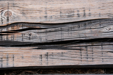wall of a house from an old cracked tree, black and brown stained aged background, wood texture with knots and annual rings