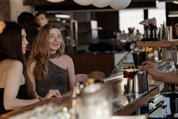 Two beautiful young women sitting at the bar