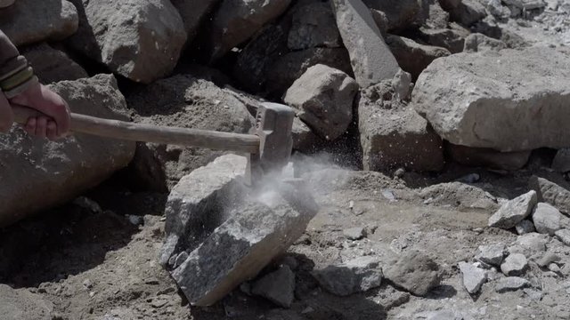 Stone work by labor of India.Stone construction work. Labor breaking rocks with hammer for construction work.