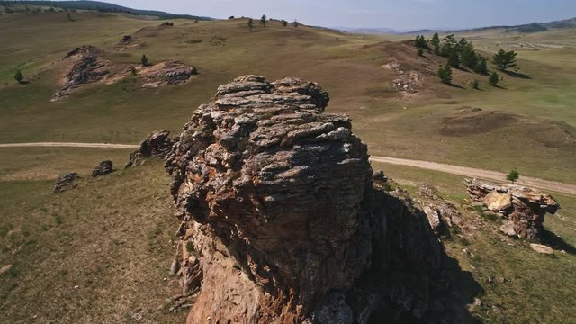 Baikal Valley spirits,Tazheran steppe, stone cliffs on the road. Aerial Summer