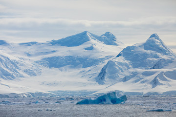 Snow and ice on the mountains near the water in Antarctica, a pristine remote landscape
