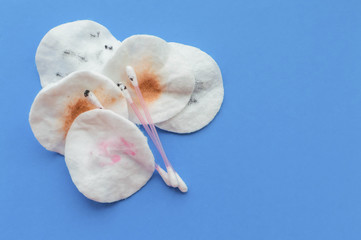 Use dirty cotton pads and cotton sticks after removing makeup on a blue background with a place for writing