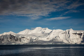 Fototapeta na wymiar Snow and ice on the mountains near the water in Antarctica, a pristine remote landscape