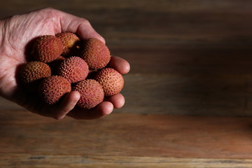hand holding out ripe lychee fruit