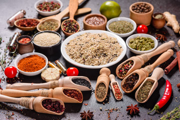 Spices and herbs over black stone background. Top view with free space for menu or recipes