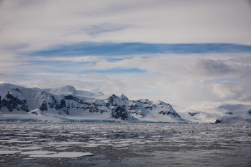 Snow and ice on the mountains near the water in Antarctica, a pristine remote landscape