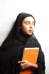 Muslim girl wearing Hijab, hugs orange book on a white background.