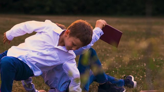 student with short hair in white shirt pushes back to classmate in glasses holding textbook close view slow motion