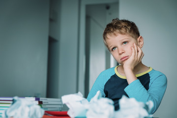 Child tired and bored of doing homework, kid stressed from learning