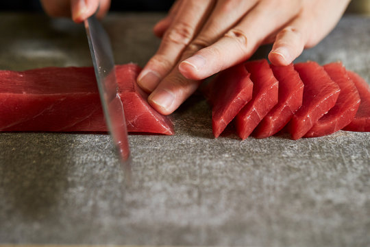 Slicing tuna saku block with sashimi knife
